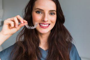 woman holding clear aligner